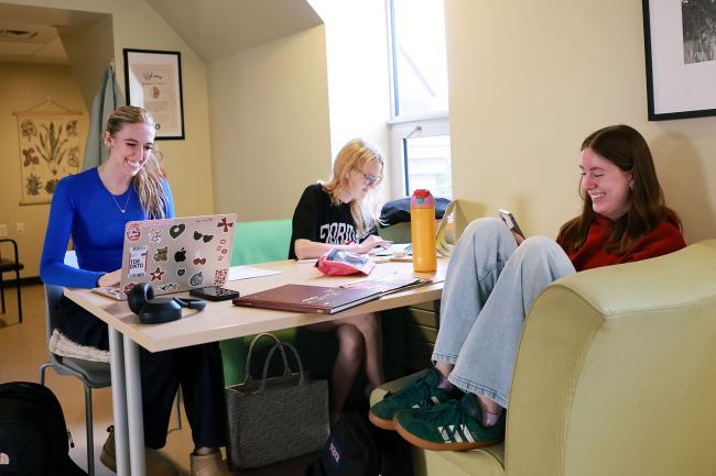 Three students are studying around a table.
